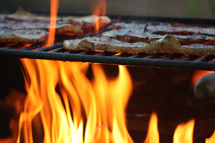 Carnes assando na grelha sobre o fogo